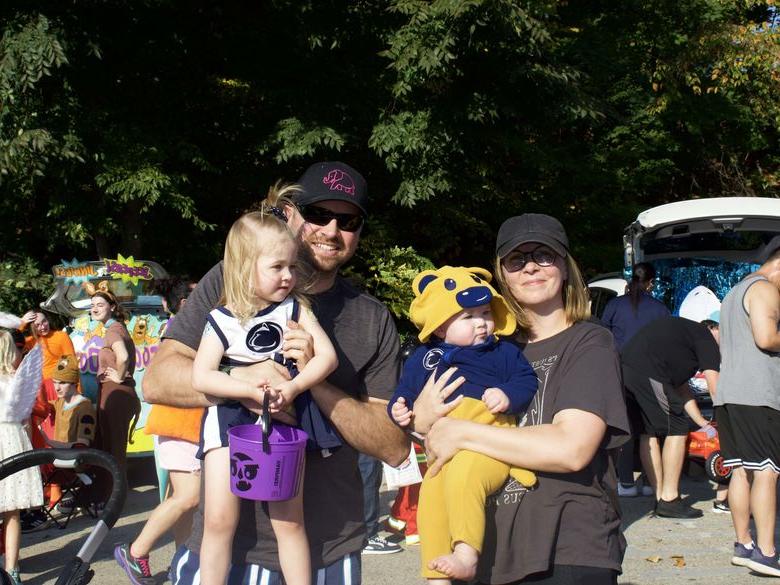 Parents holding their children for a photo at Trunk or Treat